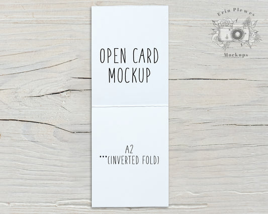 White A2 Card Mockup Open With An Inverse Fold Sitting On Rustic White Wood Vertical Orientation
