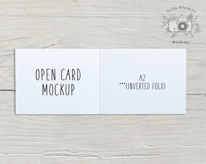 White A2 Card Mockup Open With An Inverse Fold Sitting On Rustic White Wood Landscape Orientation