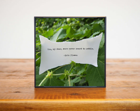 Never Meant To Settle Poem Ripped Paper Green Leaves Artwork Black Frame 4x4 Brown Wood Table Erin Plewes Creative Art